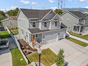 View of front facade featuring board and batten siding, roof with shingles, concrete driveway, and covered porch