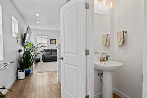 Half bathroom with laminate finished floors and recessed lighting