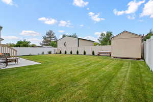 Fenced backyard featuring a patio and a storage shed
