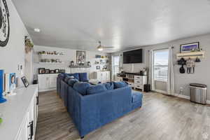 Living area featuring a textured ceiling, light wood finished floors, and ceiling fan