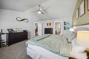 Carpeted bedroom with lofted ceiling, ensuite bathroom, and a ceiling fan