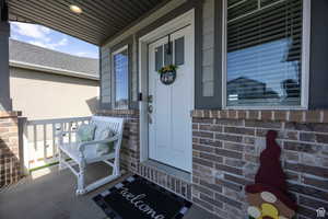 Property entrance with a porch and brick siding