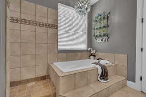 Bathroom with a garden tub and a chandelier
