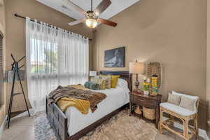 Tiled bedroom with a ceiling fan and baseboards