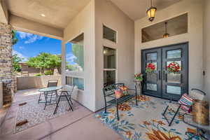 Entrance to property with french doors, stucco siding, and a patio
