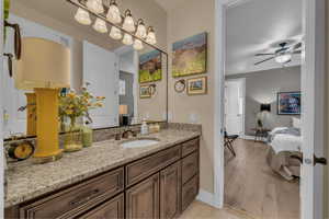 Bathroom with vanity, a ceiling fan, and ensuite bath