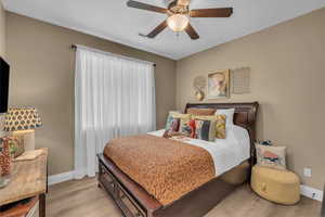 Bedroom with light wood-style floors and ceiling fan