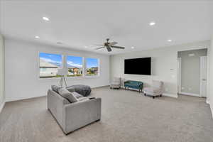 Living area featuring light colored carpet, recessed lighting, and a ceiling fan