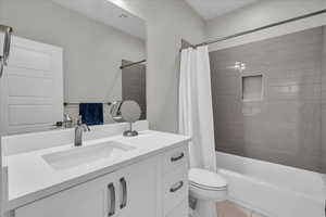 Bathroom featuring vanity, shower / bath combination with curtain, and tile patterned flooring