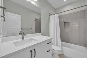 Full bath with vanity, shower / bathtub combination with curtain, and light tile patterned floors