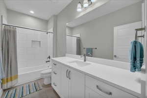 Bathroom featuring vanity, shower / bath combo, and tile patterned flooring