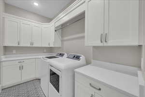 Washroom with independent washer and dryer, cabinet space, and recessed lighting