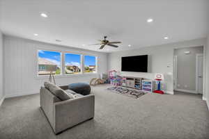 Carpeted living room with recessed lighting and a ceiling fan