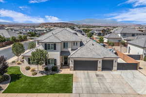 Traditional-style house featuring a residential view, stucco siding, an attached garage, and a tile roof