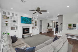 Living area with recessed lighting, stairway, ceiling fan, a glass covered fireplace, and built in features