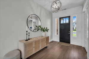 Entrance foyer featuring a chandelier and dark wood-style flooring