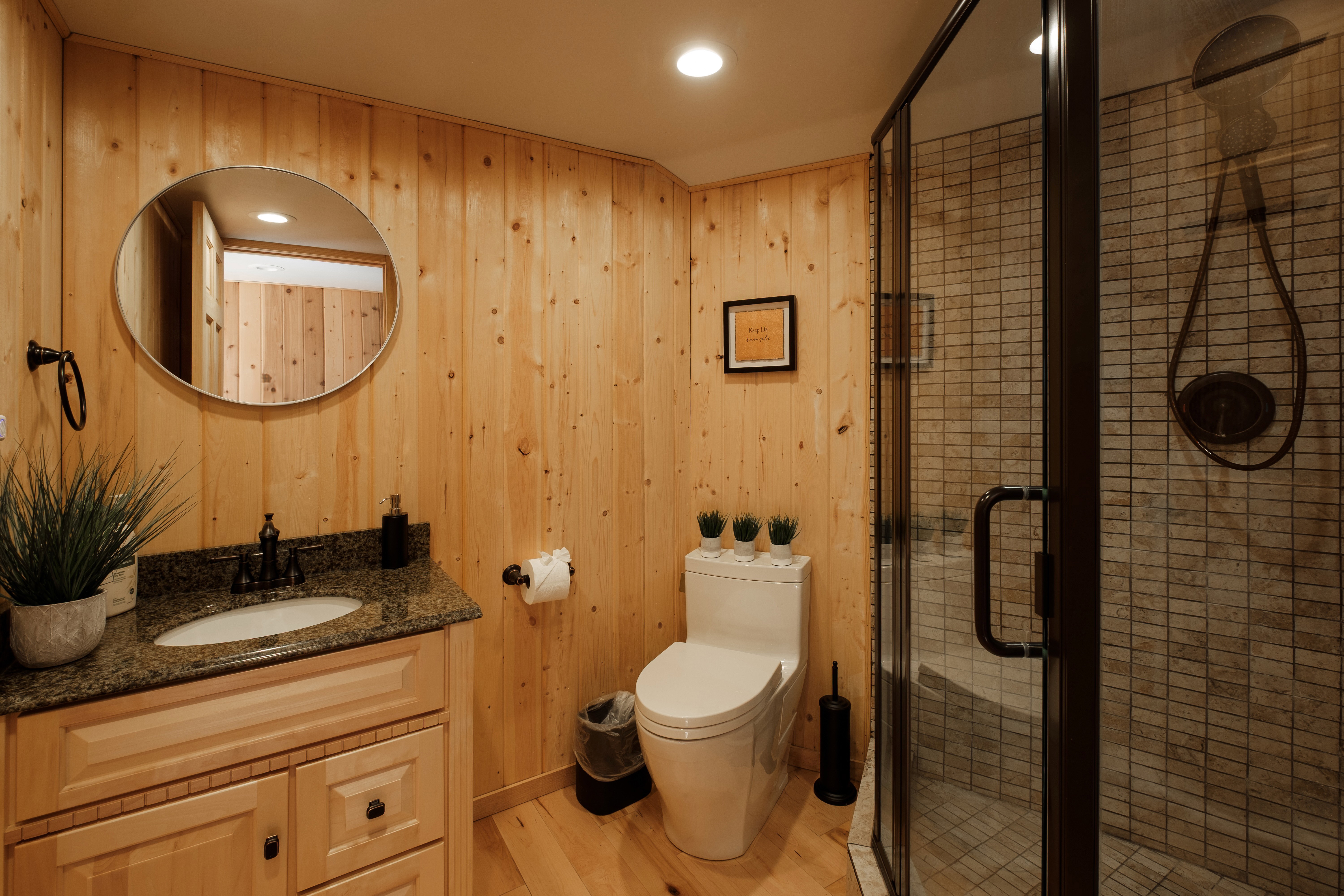 Bathroom with vanity, wood finished floors, a stall shower, wooden walls, and recessed lighting