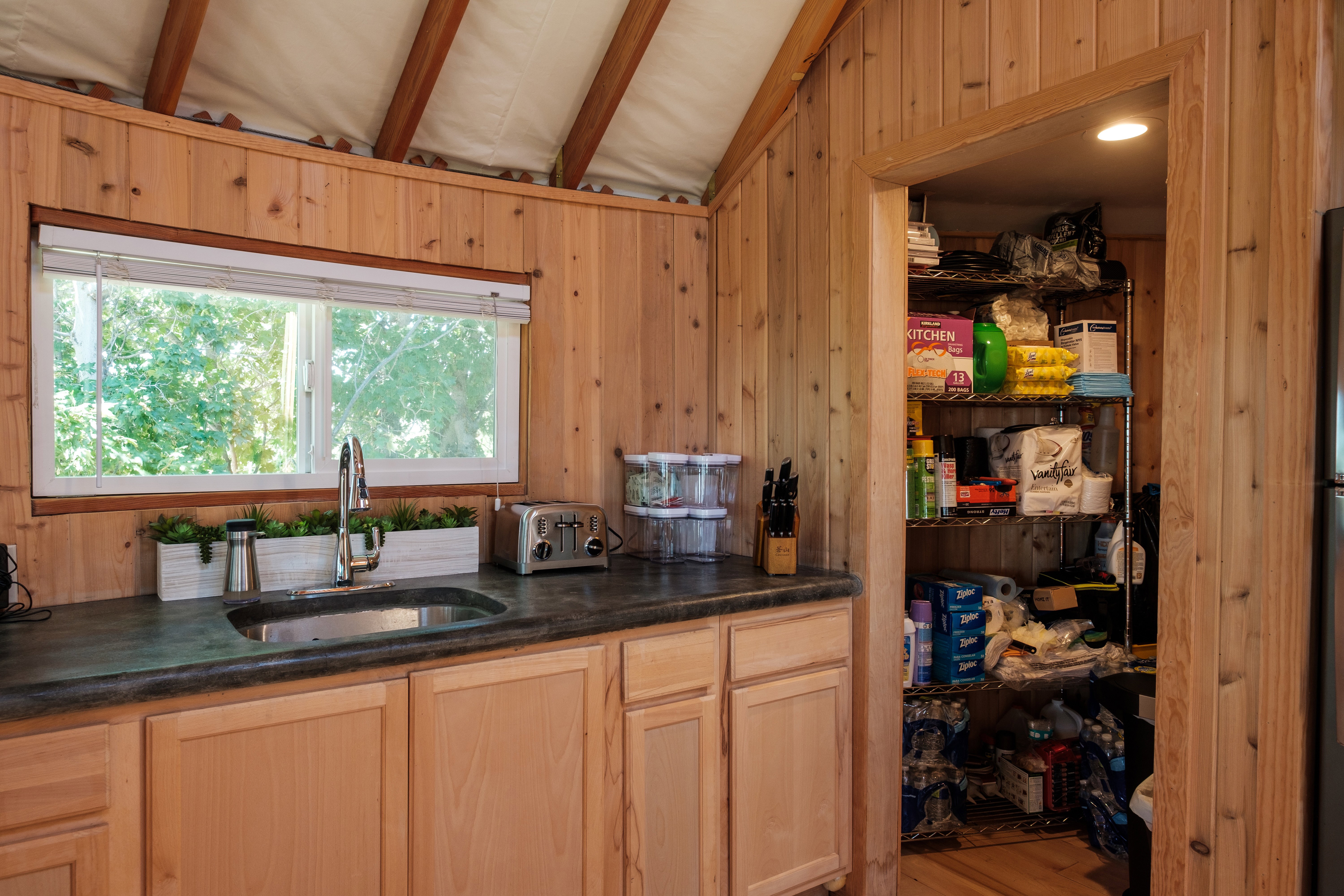 Kitchen featuring wood walls, beam ceiling, and wood finished floors