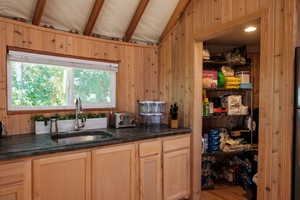 Kitchen featuring wood walls, beam ceiling, and wood finished floors