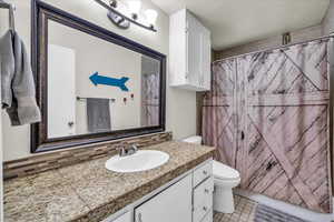 Full bathroom featuring vanity, backsplash, tile patterned floors, and a shower with shower curtain