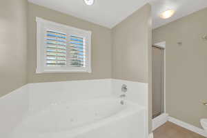 Bathroom featuring a bath, tile patterned flooring, and a shower stall