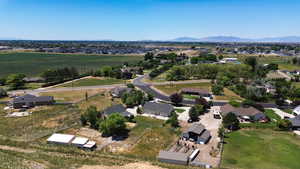 Aerial view of property and surrounding area featuring a mountain backdrop and nearby suburban area