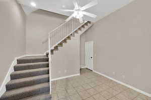 Staircase featuring a ceiling fan, tile patterned floors, and recessed lighting