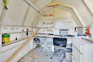 Office with vaulted ceiling, cooling unit, and a workshop area