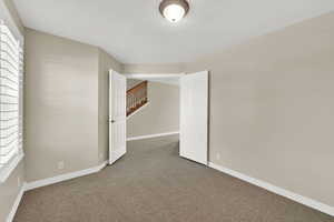 Carpeted spare room featuring baseboards