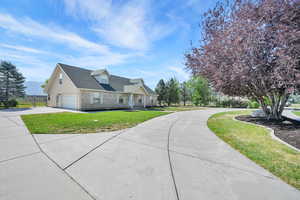 View of front of home featuring driveway, stone siding, and a garage