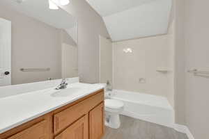 Full bathroom with vanity, lofted ceiling,  shower combination, and tile patterned floors