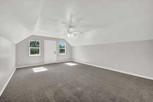 Additional living space with carpet, ceiling fan, and lofted ceiling