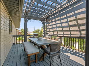 Wooden terrace with outdoor dining area and a pergola