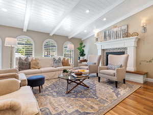 Living room with wood finished floors, healthy amount of natural light, a tile fireplace, and recessed lighting