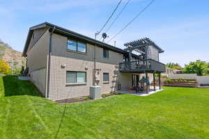 Rear view of house featuring a patio, a pergola, and a wooden deck