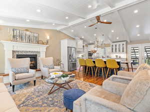Living room with dark wood-style floors, a fireplace, ceiling fan, recessed lighting, and wooden ceiling