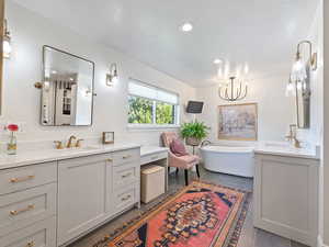 Full bathroom featuring tile patterned floors, vanity, a freestanding tub, and recessed lighting