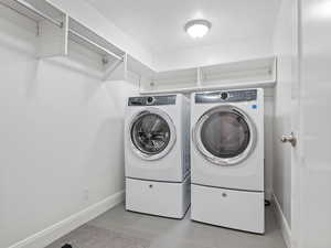Laundry room featuring washing machine and clothes dryer and tile patterned flooring