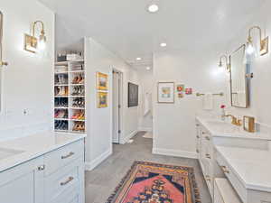 Bathroom featuring two vanities, recessed lighting, and a textured ceiling