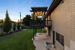View of yard with a patio, a wooden deck, and a pergola