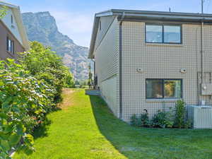 View of side of property featuring a mountain view and a yard