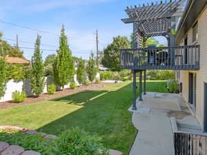 Fenced yard with a pergola, a patio, and a wooden deck
