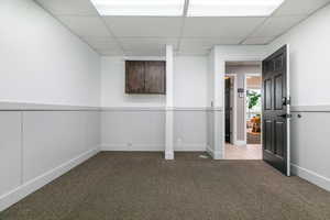 Basement with carpet floors and a drop ceiling