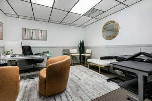 Carpeted office space with a drop ceiling