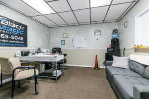 Carpeted office featuring a paneled ceiling