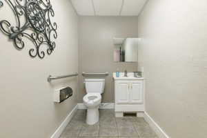 Bathroom with vanity, a drop ceiling, and tile patterned floors