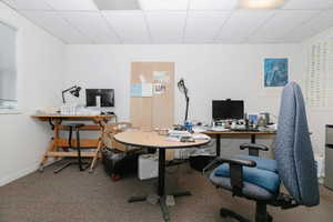 Home office featuring a drop ceiling and carpet floors