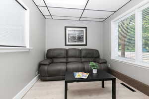 Living area with a drop ceiling and light wood-style flooring