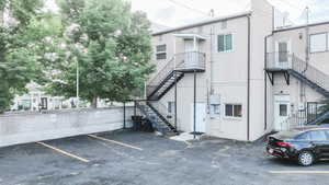 View of building exterior with stairway and uncovered parking
