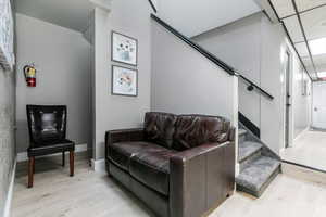 Living area with light wood finished floors, stairs, and a textured wall